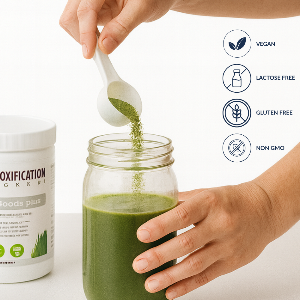 Person adding green powder to a glass of green smoothie with product packaging and certification icons.